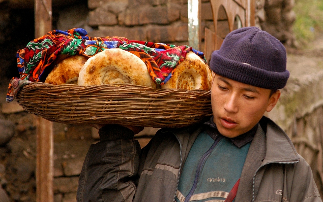 jeune homme porte des pains dans un panier